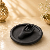 Matte black ceramic incense holder featuring an offering hand with a stick hole on a round ash-catching tray.
