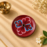 Leela round maroon wooden incense holder with a hand-painted blue and pink floral pattern