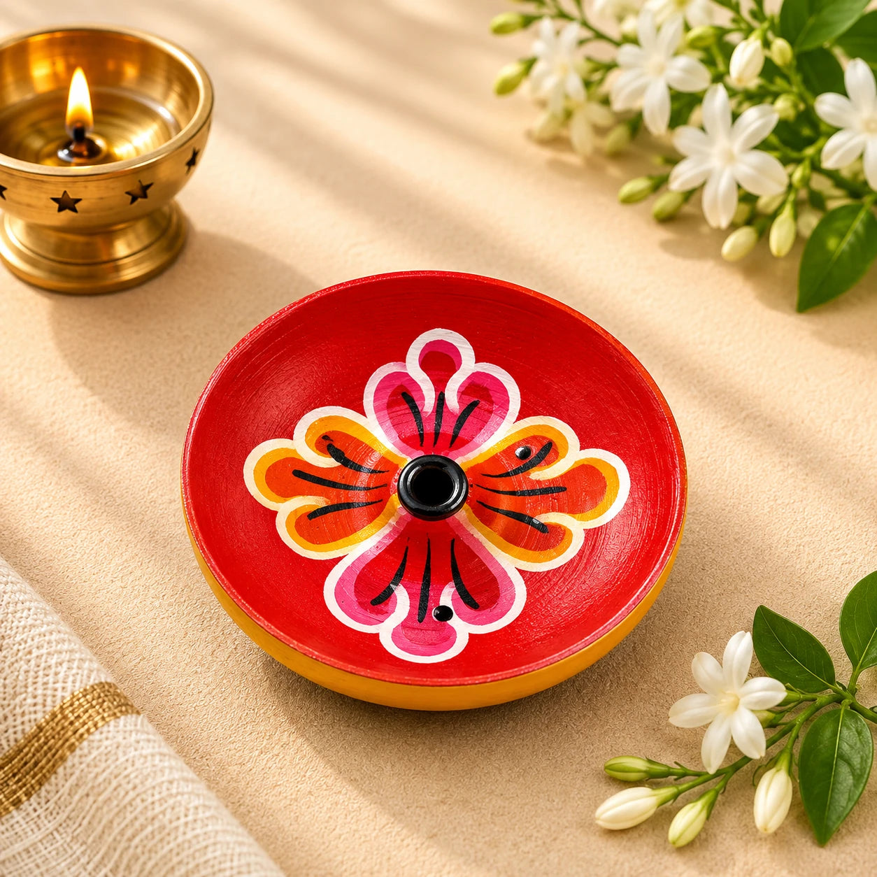 Leela round red wooden incense holder with a hand-painted pink, orange and white floral pattern
