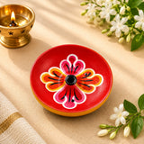 Leela round red wooden incense holder with a hand-painted pink, orange and white floral pattern
