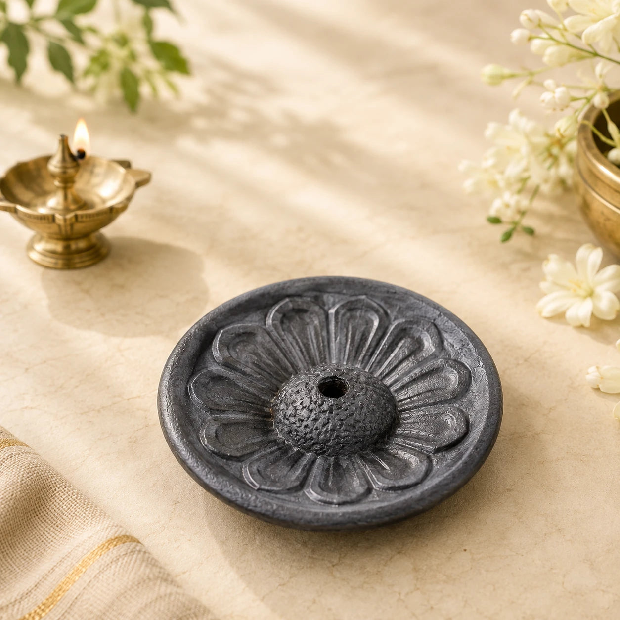 Leela round charcoal-grey terracotta incense holder with a carved lotus design and central opening
