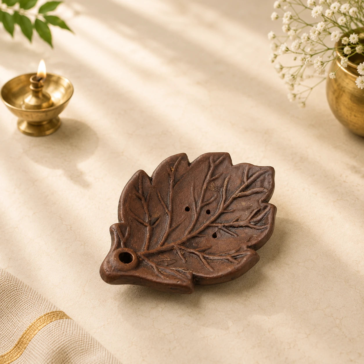 Leela handmade leaf-shaped clay incense holder in a dark brown finish with carved vein details