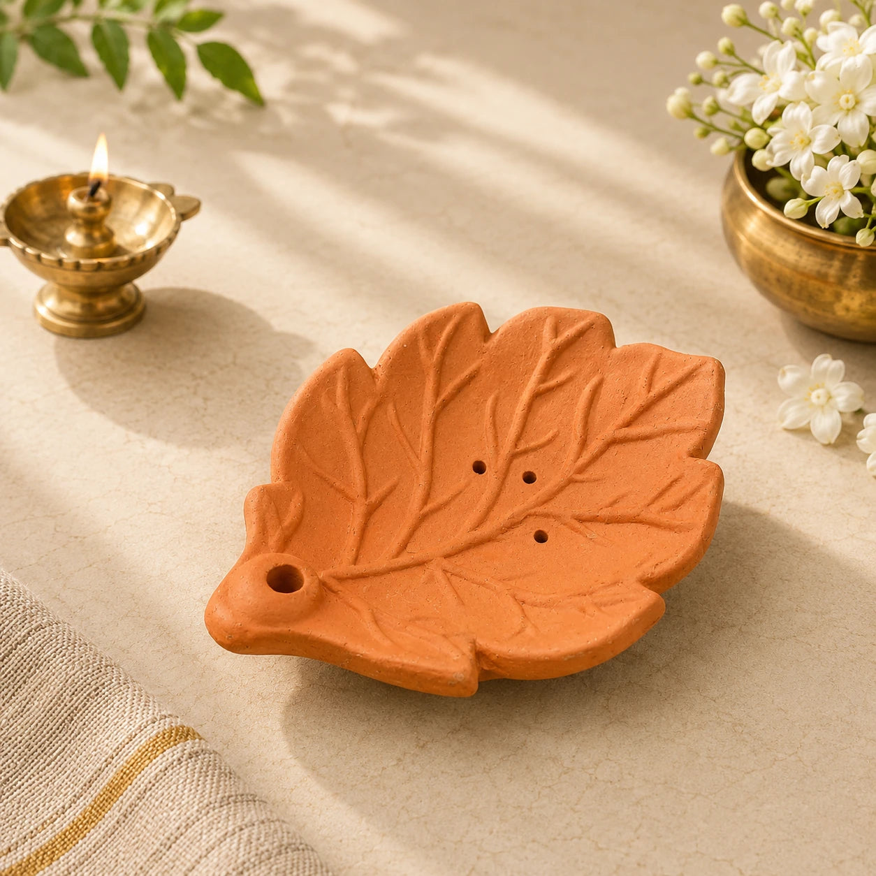 Leela handmade leaf-shaped clay incense holder in a terracotta finish with carved vein details