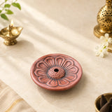 Leela round pink terracotta incense holder with a raised lotus-petal design and central opening
