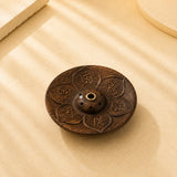Leela round wooden incense burner carved with lotus petals, sacred Om Mani Padme Hum symbols and a central incense holder.