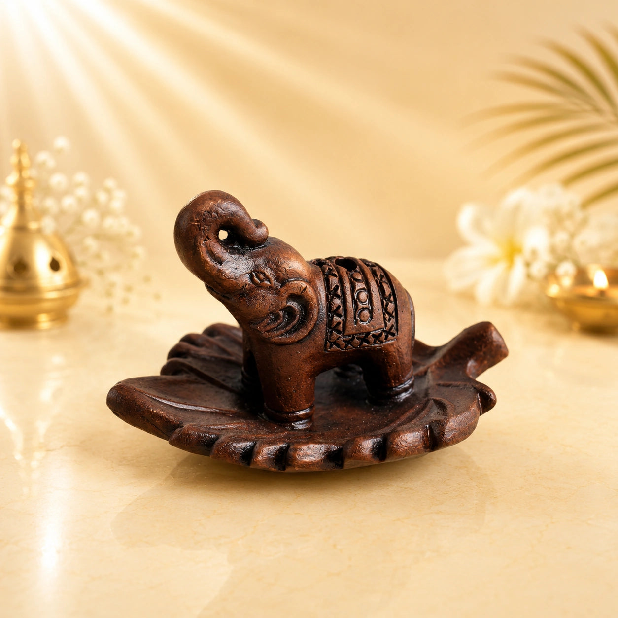 Leela terracotta incense burner featuring a carved elephant with a raised trunk on a decorative leaf-shaped tray.